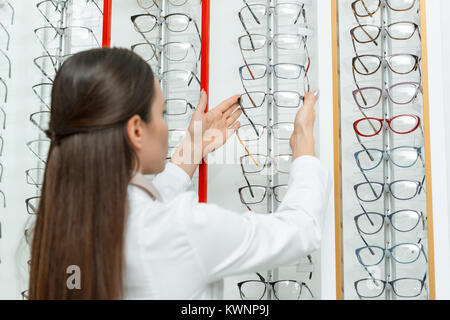Focus sélectif de l'optométriste en tenant les lunettes à partir de la tablette dans optics Banque D'Images