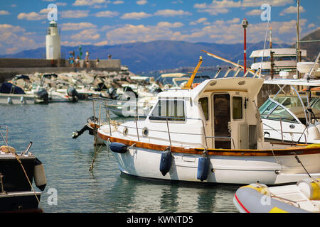 Petit bateau de pêche dans le port de Camogli avec ciel bleu et le phare en arrière-plan Banque D'Images