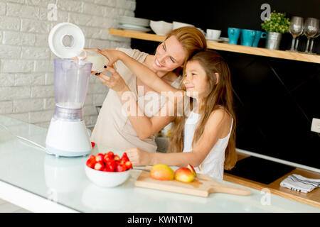 Mère et fille la préparation de jus sains à partir d'ingrédients frais dans la cuisine Banque D'Images