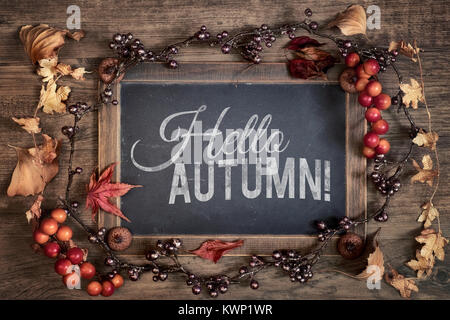 Tableau noir avec texte 'Bonjour' de l'automne avec l'automne décorations sur bois. Vue d'en haut, l'image. Banque D'Images