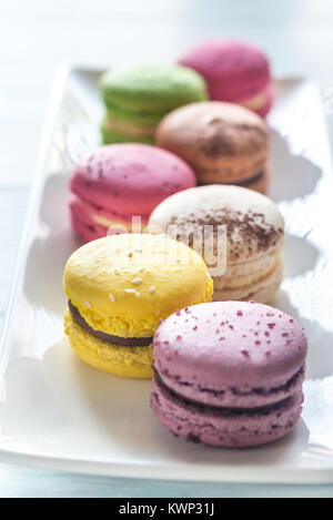 Macarons colorés sur la plaque blanche Banque D'Images