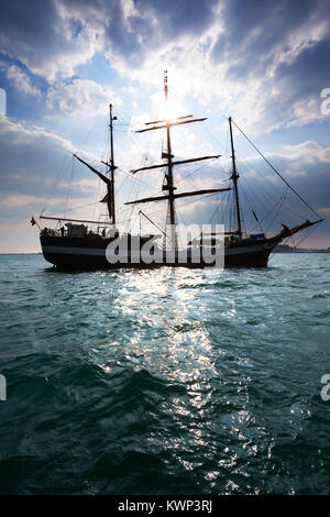 Pelican grand voilier voile de Londres dans la baie de Weymouth, Dorset, UK. La silhouette du soleil de l'après-midi par Banque D'Images