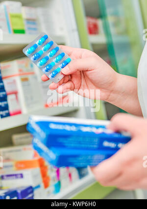 Pharmacien holding medicine box et gélules en pharmacie pharmacie. Banque D'Images