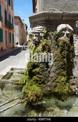TOURVES, FRANCE - CIRCA JUILLET 2015 têtes de pierre et la fontaine à l'angle de l'église de Tourves Banque D'Images