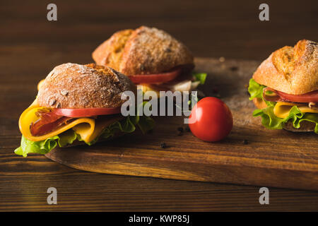 Des sandwichs au fromage et tomate cerise on cutting board Banque D'Images