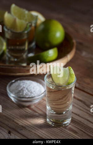 La Tequila avec du sel et lime slices sur de vieilles tables en bois. Banque D'Images