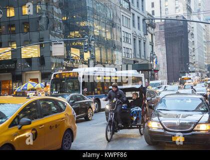 Braves femmes du froid et des vapeurs dans un pedicab sur la 5e Avenue à Manhattan, pendant la saison de vacances de Noël. Banque D'Images