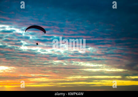 Vol en parapente motorisé haut jusqu'au ciel par le coucher du soleil Banque D'Images