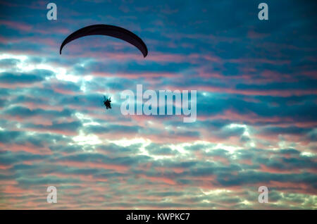 Vol en parapente motorisé haut jusqu'au ciel par le coucher du soleil Banque D'Images