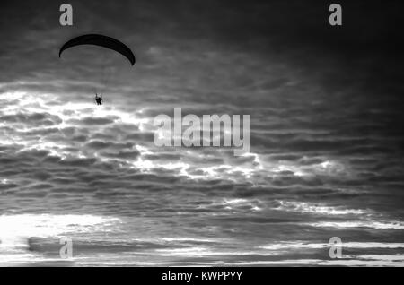 Vol en parapente motorisé haut jusqu'au ciel par le coucher du soleil Banque D'Images