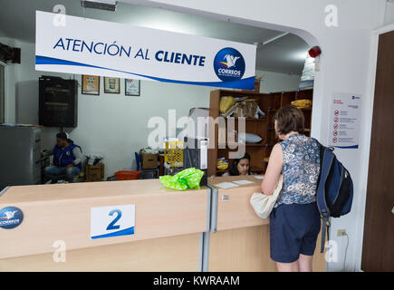 Une femme au guichet dans un bureau de poste, à Puerto Ayora, l'île de Santa Cruz, Galapagos, Equateur Amérique du Sud Banque D'Images