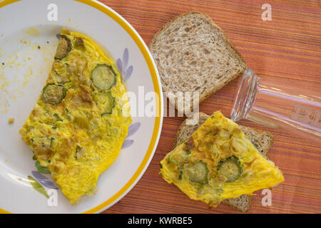 Faire un sandwich rempli d'omelette aux courgettes Banque D'Images