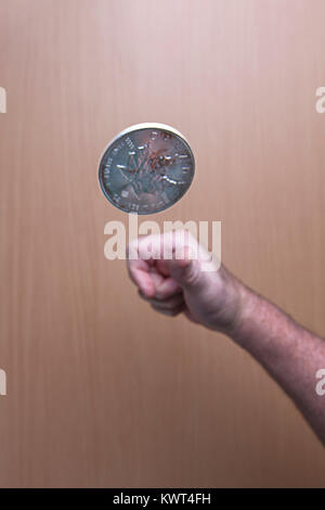 Une image conceptuelle de l'inversion d'une pièce d'argent canadien en l'air. Banque D'Images