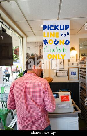 Un homme attend dans la file pour prendre un pain challah pour le peuple juif de grandes fêtes de Rosh Hashanah (le Nouvel An) à un compteur spécial avec un signe 'lecture de ligne uniquement' challah ronde à Izzy's bagels de Brooklyn, un deli boulangerie casher juive et dans la Silicon Valley ville de Palo Alto, Californie, le 20 septembre 2017. Dans la religion juive, le round challah représente le cycle de l'année. Banque D'Images