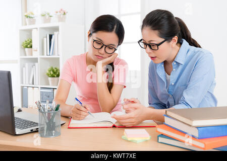 Beauté attrayante college student girl doing homework étudie à l'école avec des enseignants accueil l'ennui et de fatigue. Banque D'Images