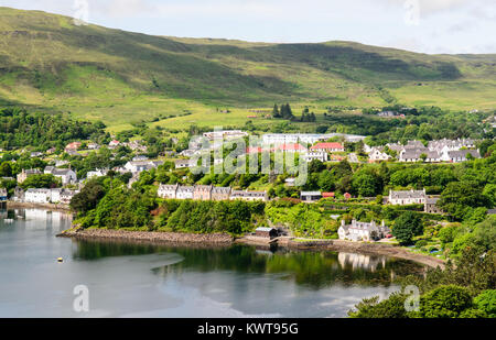 Les maisons sont nichés parmi les arbres sur la côte sous les montagnes de l'île de Skye à Portree dans l'ouest des Highlands d'Écosse. Banque D'Images