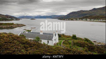 L'île rocheuse d'Eilean Bàn dans l'étroit détroit de la mer le Kyle of Lochalsh, avec l'île de Skyle vers la droite. Banque D'Images