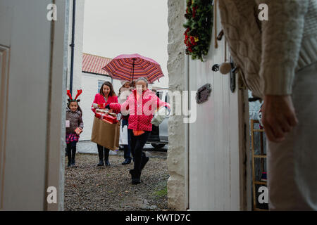 Famille excité d'arriver à leurs grands-mères chambre à l'époque de Noël. Banque D'Images