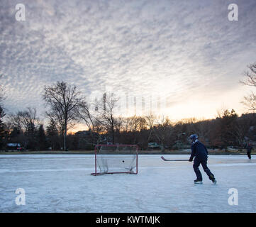 Le tournage d'un joueur de hockey sur glace sur un étang gelé rondelle Banque D'Images