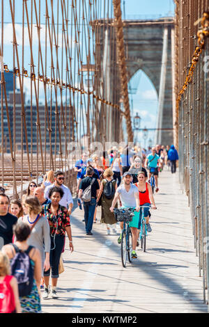 Personnes à pied et à vélo sur le pont de Brooklyn à New York City, USA. Le Pont de Brooklyn est une attraction touristique très populaire. Banque D'Images