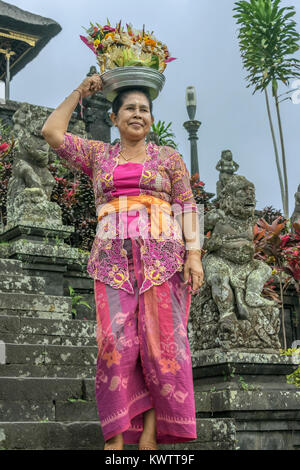 Femme adorant à Pura Besakih avec un panier de fleurs sur sa tête, Bali, Indonésie Banque D'Images