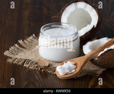 Coconut oil and fresh coconut on wooden table Banque D'Images