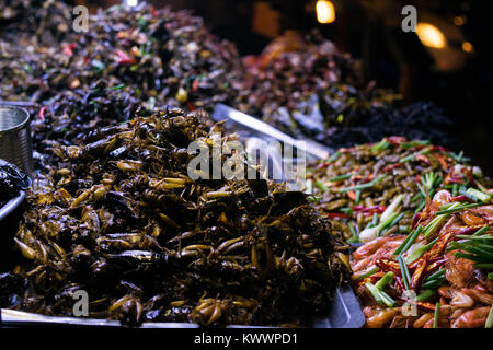 Un étal vendant de l'alimentation de rue cuisine asiatique, y compris les insectes frits crevettes blattes grillons des oeufs de cailles à Phnom Penh, Cambodge, Asie du Sud Est Banque D'Images