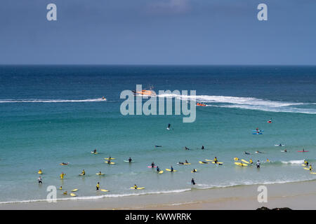 Un été à la plage de St Ives en Cornouailles. Les patrouilles de sauvetage de la RNLI au large pendant les surfeurs et les touristes jouit du beau temps ensoleillé. Banque D'Images