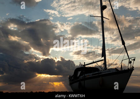 Silhouette d'un bateau à voile au coucher du soleil Banque D'Images