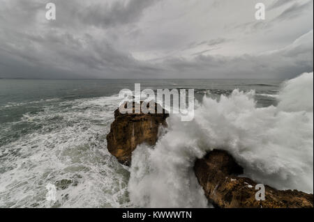 Le fracas des vagues avec un moody sky au Farol Da Nazare Banque D'Images