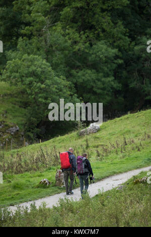 2 mâle randonneurs et promeneurs avec des sacs à dos, marcher ensemble le long sentier national sentier Pennine Way - près de Malham Cove, Yorkshire, Angleterre, Royaume-Uni. Banque D'Images