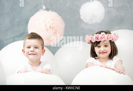 Adorable Kids jouer des ballons blancs géants Banque D'Images