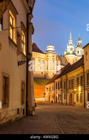 La nuit tombe sur la rue Kanonicza dans la vieille ville de Cracovie, Pologne. Le château de Wawel à distance. Banque D'Images