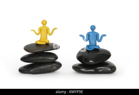 Deux hommes de couleur de la pâte à modeler méditant dans la position du lotus noir sur des pierres d'équilibrage. With clipping path isolé sur fond blanc Banque D'Images