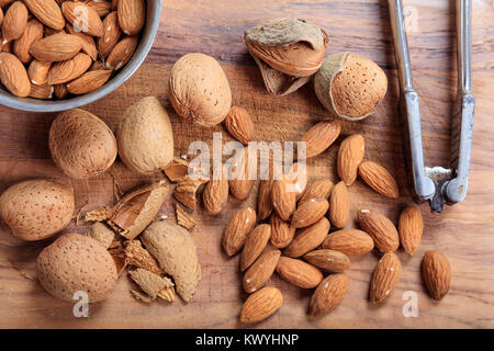 Les amandes et d'un casse-noix sur une table en bois Banque D'Images