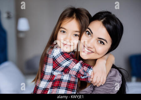 Deux heureux belles filles soeurs amis hug et rire sur le lit Banque D'Images