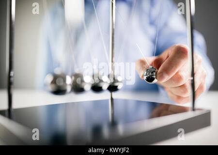 Newton's cradle businessman libérant ball concept pour la cause et l'effet Banque D'Images