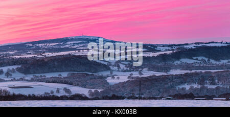 Vue panoramique sur le Shropshire Hills à l'hiver dans la neige avec le lever du soleil ciel rose vif Banque D'Images