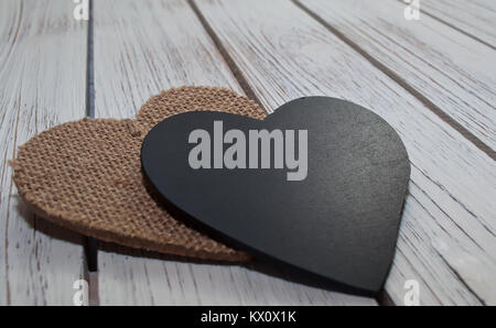 Close up d'un coeur noir et brun portant sur une table en bois blanc Banque D'Images