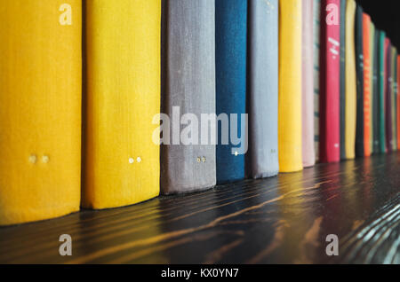 Stand de livres dans une rangée sur l'étagère en bois foncé Banque D'Images