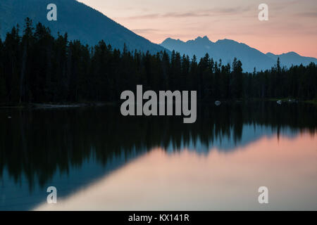Un coucher de soleil rempli de fumée provenant des feux de forêt se reflétant dans les eaux du lac de chaîne. Parc National de Grand Teton, Wyoming Banque D'Images
