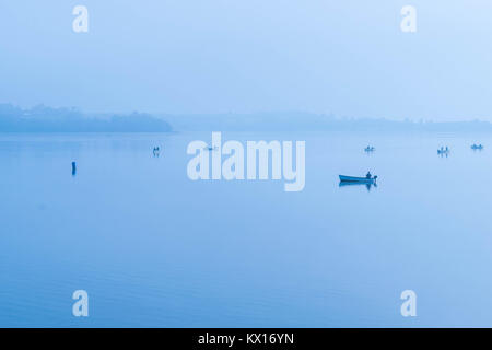 La pêche dans la brume matinale sur le lac en eaux Dunchurch Park, Royaume-Uni Banque D'Images