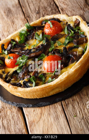 Tarte aux champignons ouverte avec le fromage, le persil et les tomates sur la table verticale. Banque D'Images