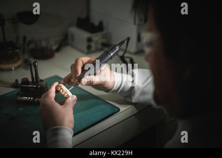 Parution du modèle. L'homme travaillant sur prothèse dentaire. Banque D'Images