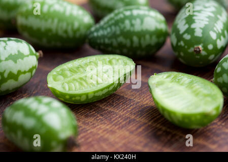 Cucamelon fruits, également connu sous le nom de cornichons aigre mexicain Mexicain, concombres Melothria scabra, ou sur un fond de bois brun foncé Banque D'Images