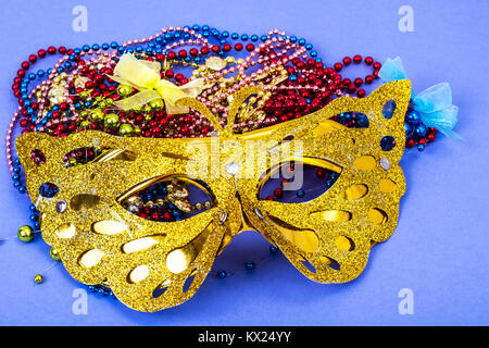 Masque de carnaval d'or avec perles de couleur sur fond violet Banque D'Images