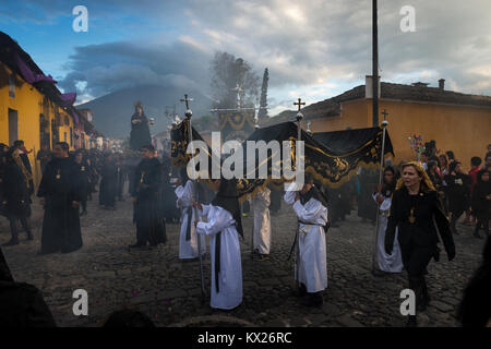 Antigua, Guatemala - Avril 19, 2014 : Gens portant des robes noires et des hottes dans une rue de la vieille ville d'Antigua au cours d'une procession de la Semaine Sainte Banque D'Images