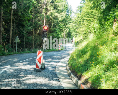 Signal rouge sur un chantier de construction sur une petite route dans les alpes Banque D'Images