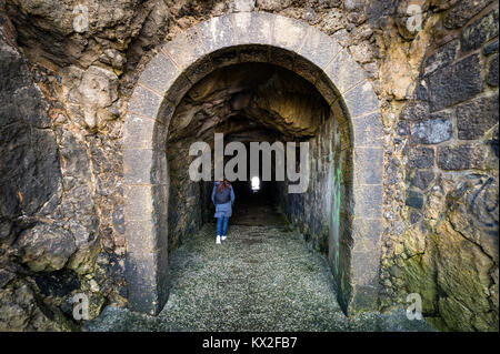 Femme marchant à travers un tunnel noir Banque D'Images