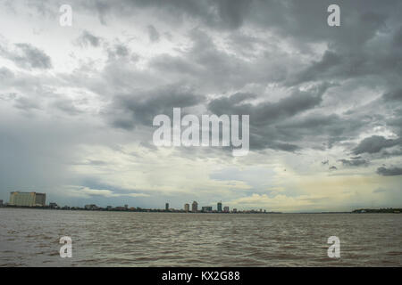 Où la rencontre du Mékong, rives du Tonlé Sap à Phnom Penh au Cambodge, en Asie du sud-est, de l'eau de la rivière brun, gris nuage épais couvert de mousson. Banque D'Images